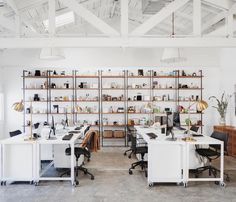 an office with two desks and shelves full of items