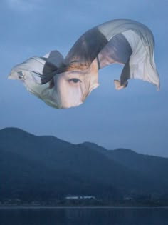 a kite flying in the air with mountains in the background