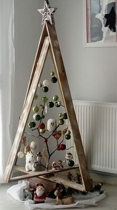 a wooden christmas tree with ornaments on it and an arrow pointing to the right side