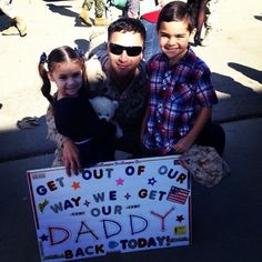 a man and two children holding a sign that says get out of our way we get your daddy back today