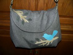 a gray purse with a blue bird on it