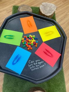 a child's play table with colored paper and scissors