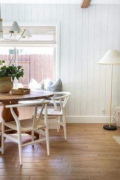 a dining room table with two chairs and a potted plant on the table next to it