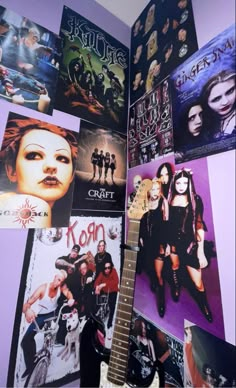 a guitar sitting on top of a purple wall covered in pictures and music memorabilias