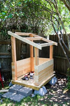 a wooden outhouse sitting in the middle of a yard