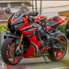 a red and black motorcycle parked on the street