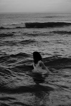 a woman swimming in the ocean at sunset