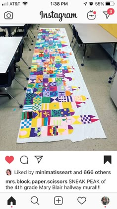 a table runner made out of quilts on the floor in an empty school room