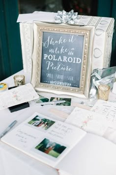 a table topped with lots of cards and pictures next to a box filled with photos