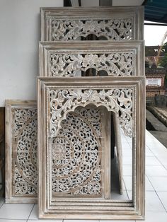 three wooden frames sitting on top of a tiled floor