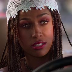 a close up of a person wearing a headband with braids on her hair