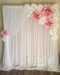 the backdrop is decorated with pink flowers and white drapes for an elegant wedding ceremony