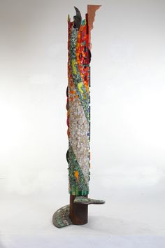 a sculpture made out of various pieces of glass and wood on top of a metal stand