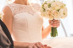 the bride is holding her bouquet and smiling