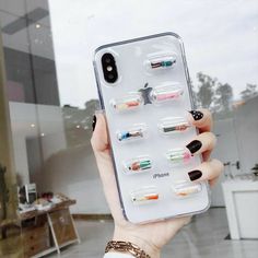 a woman holding up a phone case with multiple compartments on it in front of a window