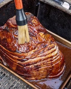 a large roasting pan with a brush sticking out of it's top meat