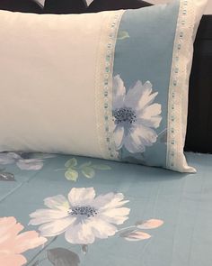 a bed with blue and white flowers on it