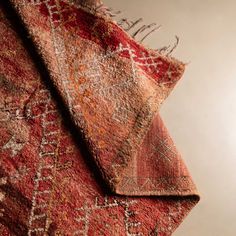 an old rug is laying on top of a table with a light in the background