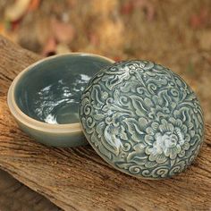 a blue and white bowl sitting on top of a wooden table next to another bowl