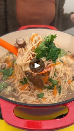 a bowl of noodles with carrots, mushrooms and parsley