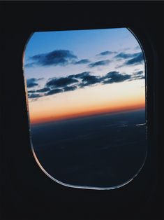 the view out an airplane window at sunset