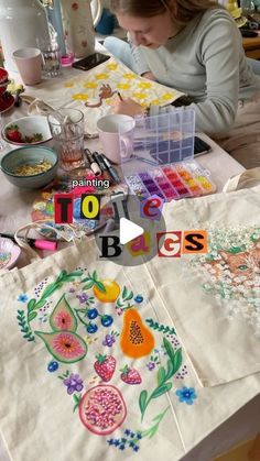 a woman sitting at a table working on an art project