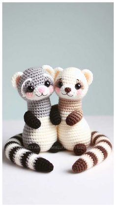 two crocheted stuffed animals sitting next to each other on top of a table