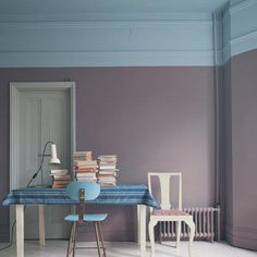 a room with two chairs and a table covered in books on top of the floor