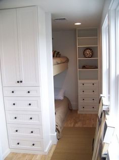 there is a bunk bed in the corner of this room with built - in shelving