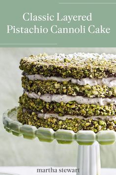 a stack of cake sitting on top of a white plate covered in pistachio