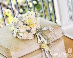 a bouquet of flowers sitting on top of an old book in front of a window