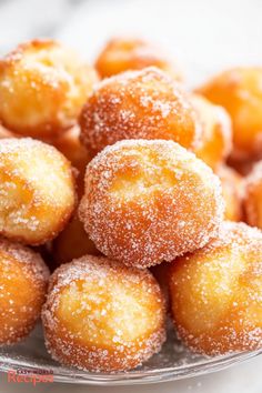 powdered sugar covered donuts in a glass bowl