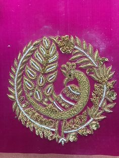 a gold and white brooch on a purple background