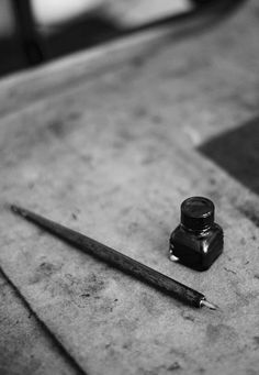 a pen and ink bottle sitting on top of a table