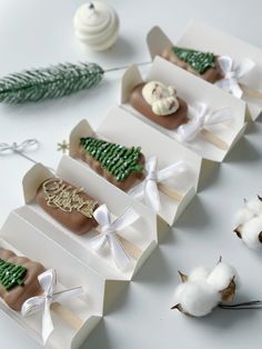 four different types of chocolates in boxes on a table with cotton floss and christmas decorations