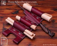 four leather knives are lined up on a wooden table with the handles down and one is holding a wood carving tool