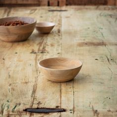 two wooden bowls sitting on top of a table