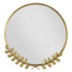 a round mirror with gold leaves on it