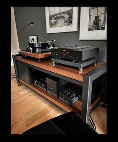 two turntables sit on top of a wooden shelf in front of a wall mounted stereo system