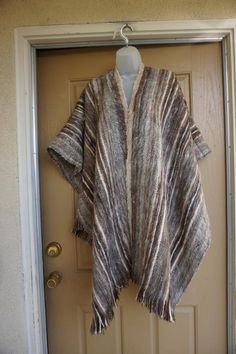 A vintage 100% alpaca shawl. One size fits most. Very soft material. Item is vintage and in very good condition.measurements taken across front laid flat  Shoulders: free size Sleeves: none Length: 40" including fringe Handwoven Wool Poncho For Fall, Vintage Fall Shawl, Cozy Brown Shawl For Fall, Cozy Long Sleeve Wool Cape, Cozy Brown Outerwear One Size, Vintage Winter Poncho One Size, One Size Alpaca Shawl For Fall, One Size Vintage Poncho For Winter, Vintage One-size Winter Poncho