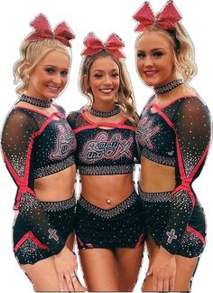 three women in black and red outfits with bows on their heads are posing for the camera