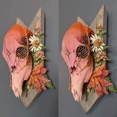 two pieces of art made out of paper with flowers and leaves on them, one of which has a skull in the middle