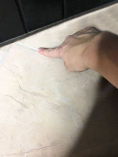 a person's hand reaching for something on the floor