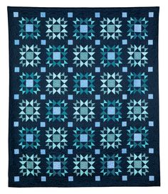 a blue and black quilt with many stars on it's sides, in the center