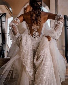 the back of a woman's wedding dress as she walks down stairs