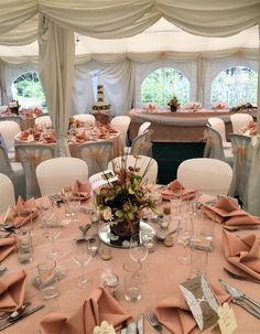 the tables are set for an event with pink napkins and silverware on them