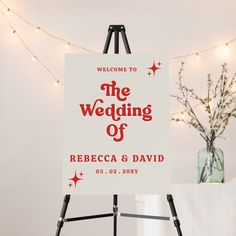 a welcome sign for the wedding of rebecca and david in front of a string of lights