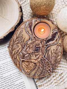 a candle sits on top of a book next to some wood slices and other items