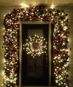 a christmas wreath with lights on the front door