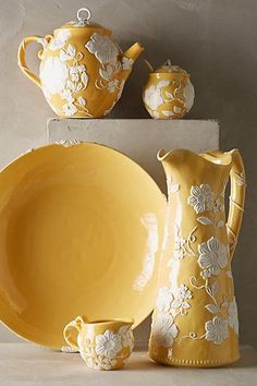 a yellow and white dinnerware set with flowers on it